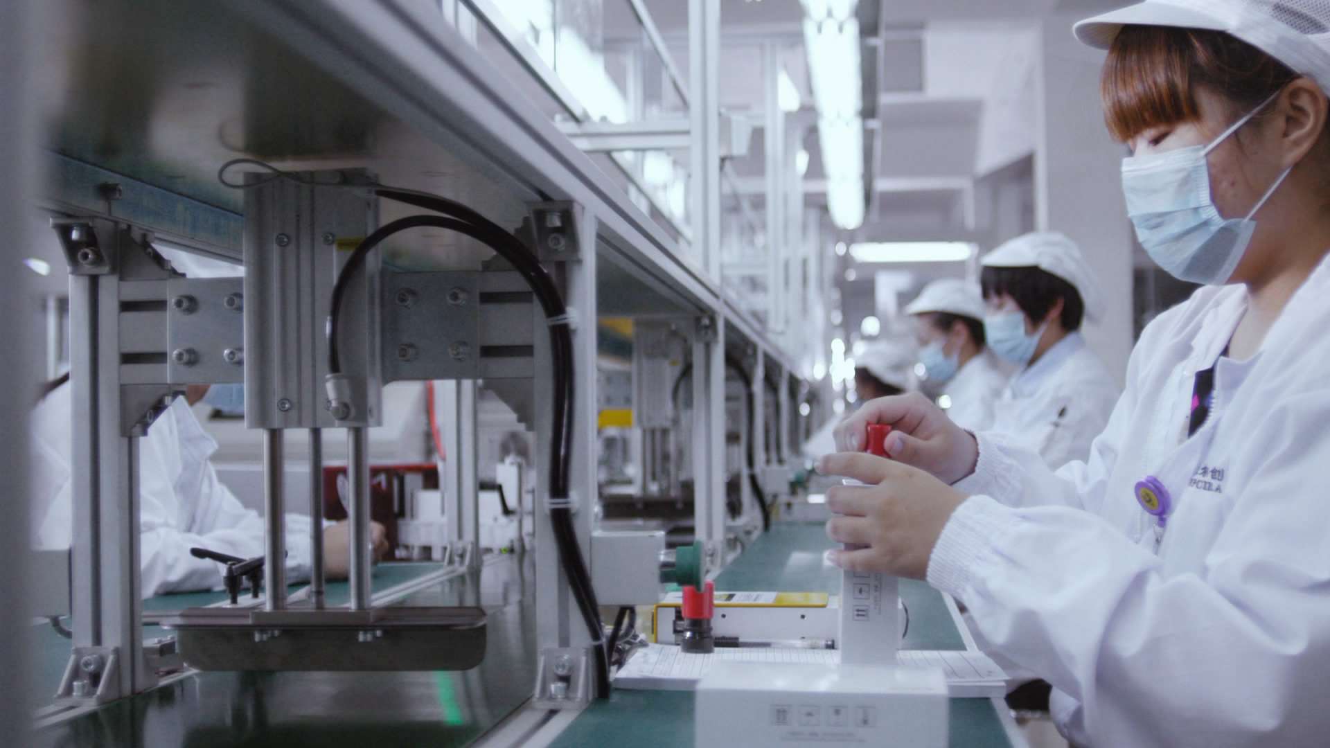 Workers manufacturing zirconia ceramic sleeves in cleanroom environment